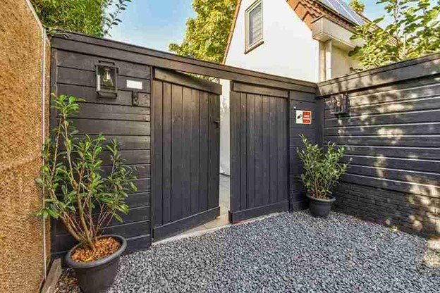 A Modern wooden double gate installed in a residential courtyard, showing clean construction and smooth gate operation.
